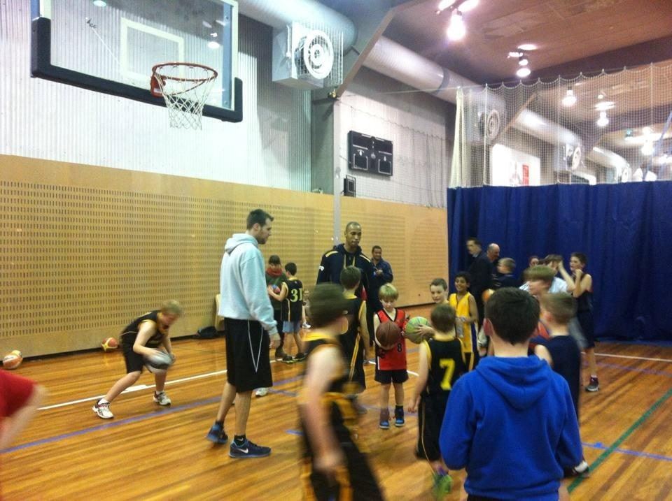 One of the Gunners players demonstrates dribbling technique to a group of junior boys on court during the clinic.