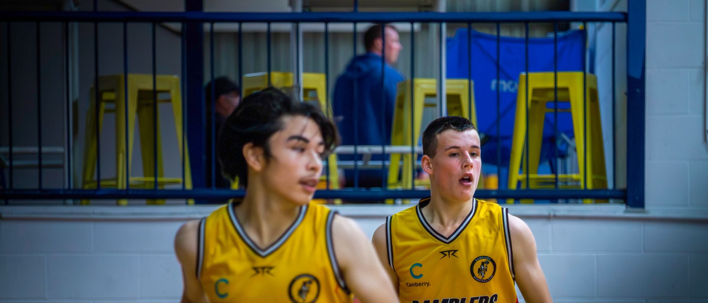 Two Ramblers juniors run up the court during a game